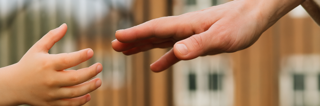 Child and adult hands reaching for each other